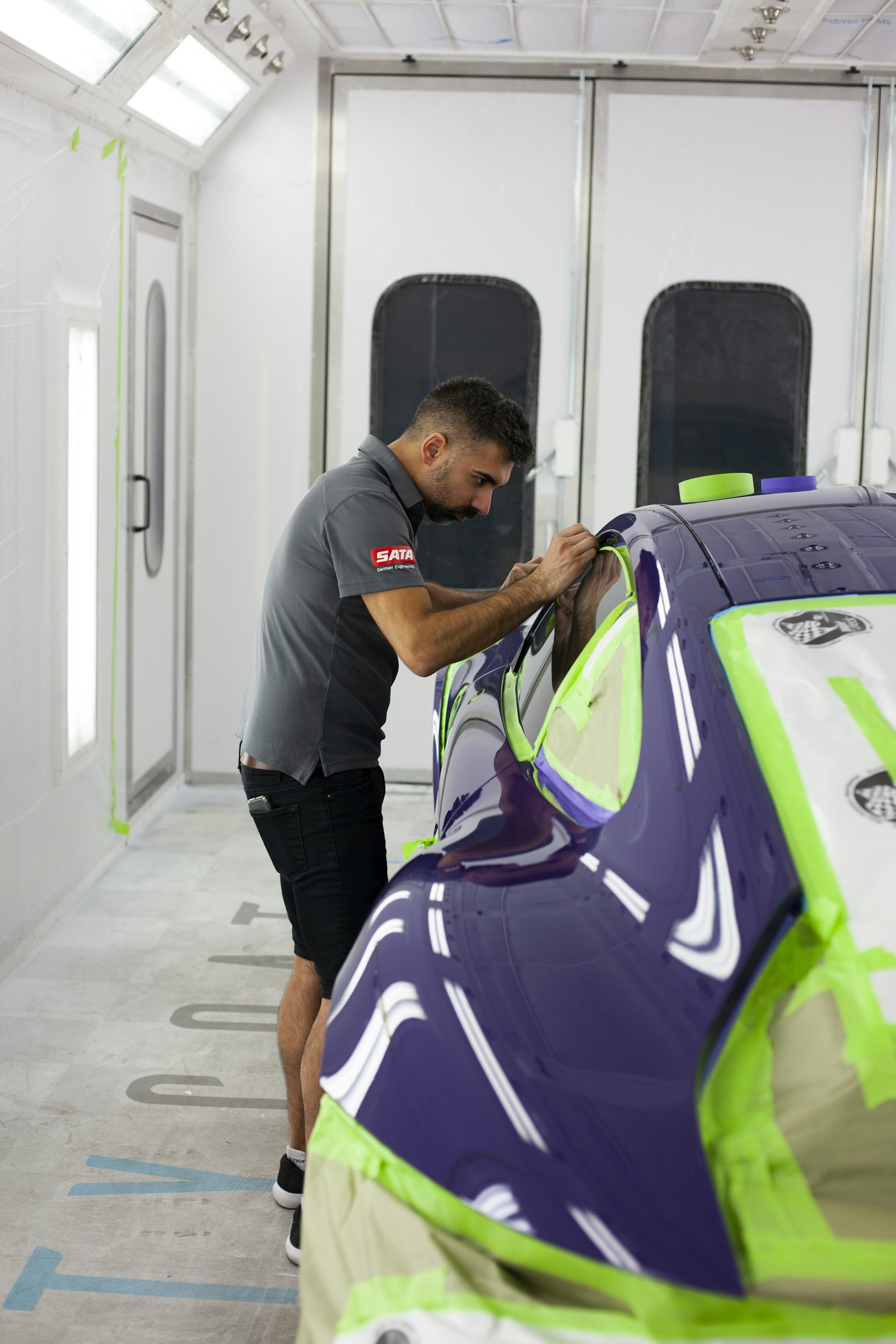 An S&A technician refinishing a vehicle in the spray booth